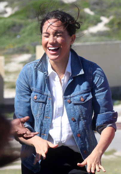 영국 메간 마클(가운데) 왕자비가 24일(현지시간) 남아프리카 케이프타운의 몬와비시 해변에서 NGO ‘Waves for Change’을 방문하는 동안 그룹 활동으로 서핑 강사 멘토들과 함께하고 있다. EPA 연합뉴스