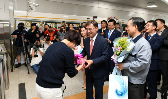 개통이 2차례나 연기되는 우여곡절 끝에 김포도시철도(김포골드라인)가 28일 첫 운행을 시작했다. 경기도 김포시는 이날 오전 5시 30분 구래역과 김포공항역에서 김포도시철도 첫차가 운행을 시작했다고 밝혔다. 사진은 김포도시철도를 이용한 첫 승객에게 축하 꽃다발을 전달하는 모습. 2019.9.28  김포시 제공
