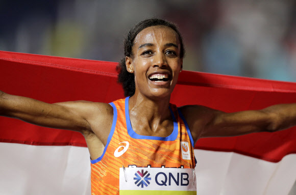 에티오피아 난민 출신 시판 하산(네덜란드)이 여자 1만m 우승을 차지한 뒤 국기를 몸에 두른 채 활짝 웃고 있다. 도하 AP 연합뉴스