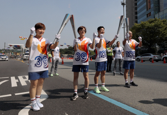 29일 오후 제100회 전국체육대회와 장애인전국체전 성화봉송 주자인 서울 아시안게임 3관왕 임춘애씨(왼쪽 두번째부터)와 사격 진종오 선수가 성화봉송을 마치고 다음주자인 여자핸드볼 은메달리스트 임오경(왼쪽), 주원홍 아시아테니스연맹 부회장에서 성화를 옮기고 있다. 2019. 09.29. 정연호 기자 tpgod@seoul.co.kr