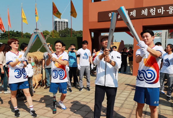 100회 전국체육대회를 앞두고 개최지인 서울에서 첫 성화봉송이 진행된 29일 오후 서울 송파구 올림픽공원에서  1986 서울 아시안게임 3관왕 임춘애씨, 장애인 아이스하키 정승환 선수, 서울시 관광체육국 주용태 국장, 서울시청 소속 사격 진종오 선수(왼쪽부터)가 토치키스를 하고 있다. 2019. 09.29. 정연호 기자 tpgod@seoul.co.kr