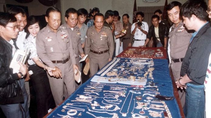 태국 경찰이 회수된 사우디 왕실의 보석을 진열해 보이고 있다. 오른쪽 수갑찬 인물이 절도범 크리앙크라이 테차몽.BBC캡처