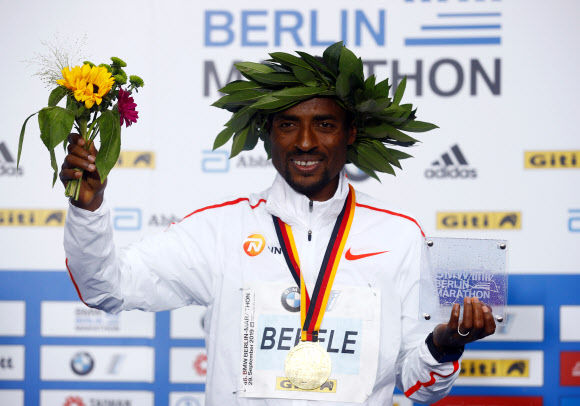 29일현지시간) 베를린마라톤에서 2시간01분41초로 엘리우드 킵초게(케냐)의 세계기록에 2초가 모자란 기록으로 우승한 케네니사 베켈레(에티오피아)가 시상식 세리머니를 펼치고 있다. 베를린 로이터 연합뉴스