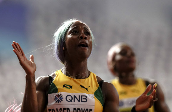 자메이카 육상 선수 셸리 앤 프레이저-프라이스가 29일(현지시간) 카타르 도하에서 열린 세계육상선수권대회 여자 100m 결선에서 금메달을 따낸 뒤 기뻐하고 있다. 이날 프레이저-프라이스는 10초 71로 올 시즌 최고 기록을 세웠다. AP 연합뉴스