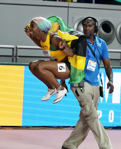 자메이카 육상 선수 셸리 앤 프레이저-프라이스가 29일(현지시간) 카타르 도하에서 열린 세계육상선수권대회 여자 100m 결선에서 금메달을 따낸 뒤 기뻐하고 있다. 이날 프레이저-프라이스는 10초 71로 올 시즌 최고 기록을 세웠다. AP 연합뉴스