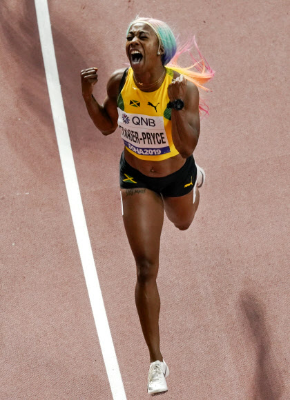 자메이카 육상 선수 셸리 앤 프레이저-프라이스가 29일(현지시간) 카타르 도하에서 열린 세계육상선수권대회 여자 100m 결선에서 금메달을 따낸 뒤 기뻐하고 있다. 이날 프레이저-프라이스는 10초 71로 올 시즌 최고 기록을 세웠다. AP 연합뉴스