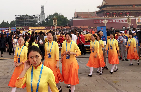 중국 건국 70주년을 맞은 1일 베이징(北京) 톈안먼(天安門) 앞에서 열병식을 앞두고 자원봉사자들이 지나가고 있다. 2019.10.1  연합뉴스