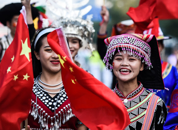 (191001) -- BEIJING, Oct. 1, 2019 (Xinhua) -- Attendees wave Chinese national flags ahead of celebrations marking the 70th anniversary of the founding of the People‘s Republic of China (PRC) in Beijing, capital of China, Oct. 1, 2019. 신화=연합뉴스