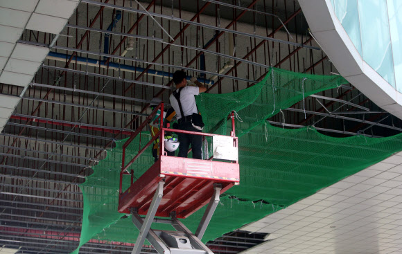 지난달 태풍 ‘타파’로 천장이 파손된 부산 해운대 전시컨벤션 시설인 벡스코에서 1일 오전 직원들이 북상하는 태풍 ‘미탁’에 대비해 천장에 그물을 다는 등 추가 피해 방지를 위한 작업을 하고 있다. 2019.10.1  연합뉴스