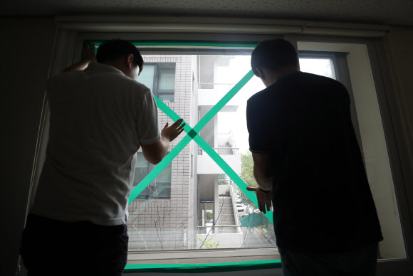 1일 대전시서구건강체련관에서 서구청 직원들이 북상하는 태풍 ‘미탁’에 대비해 창틀과 유리창에 테이프를 붙이고 있다. 2019.10.1  연합뉴스