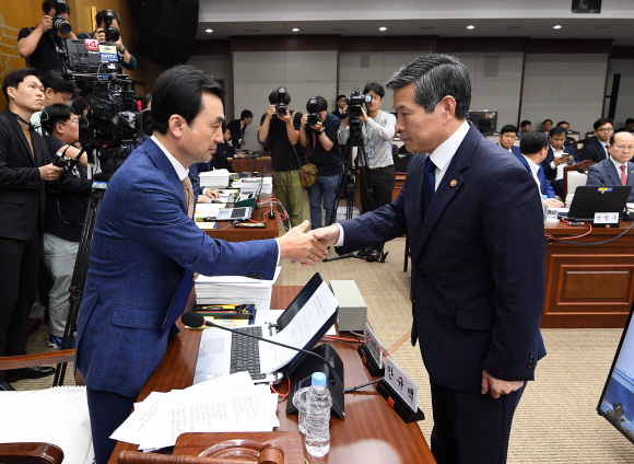 정경두 국방부 장관이 2일 오전 서울 용산구 국방부에서 열린 국회 국방위원회의 국정감사에 출석해 안규백 국방위원장에게 증인 선서문을 전달한 후 악수를 하고 있다. 2019.10.2. 오장환 기자 5zzang@seoul.co.kr