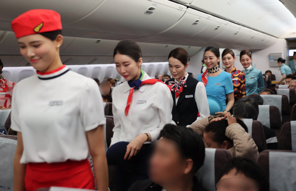 2일 오후 대한항공 창립 50주년을 맞아 대한항공 승무원들이 인천에서 호치민으로 향하는 비행기 안에서 역대 승무원 유니폼을 선보이고 있다. 대한항공은 창립 50주년을 맞아 객실 승무원들이 역대 유니폼 11종을 동시에 입고 근무하는 행사를 내달 6일까지 실시한다. 승무원들이 ‘역대 유니폼’ 을 입고 근무하게 될 국제선 노선은 호찌민을 비롯, LA, 도쿄, 베이징, 홍콩, 싱가포르, 파리, 시드니 등 이며, 국내선은 김포~부산, 김포~제주 노선 등이다. 호치민 공항사진기자단 2019.10.02