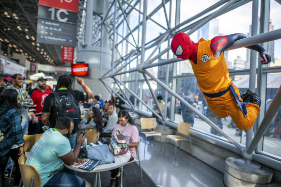 벽에 매달린 스파이더맨 복장을 한 참가자가 4일(현지시간) 미국 뉴욕 제이콥 K. 자비츠 컨벤션 센터에서 열린 ‘뉴욕 코믹 콘’에서 포즈를 취하고 있다. AP 연합뉴스