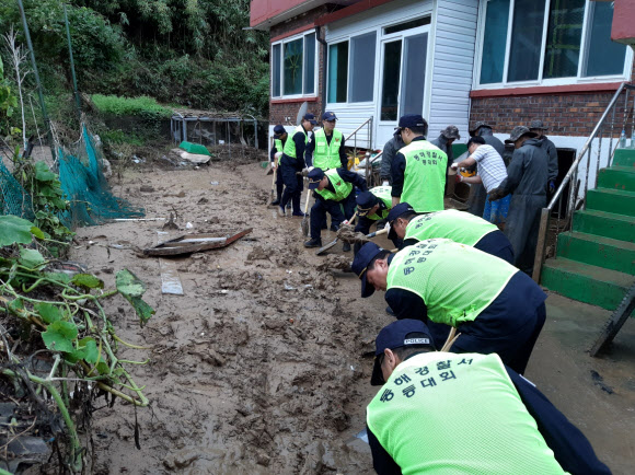 휴일인 6일 동해경찰서 직원 등이 제18호 태풍 ‘미탁’으로 피해가 난 삼척시 초곡마을에서 토사 제거 등 수해복구 활동을 하고 있다. 2019.10.6  동해경찰서 제공