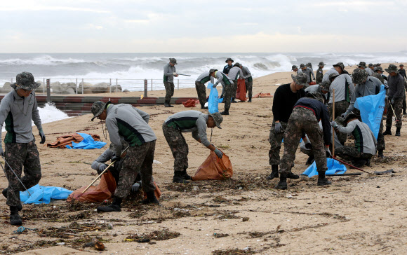 6일 오전 강원 강릉시 강문해변에서 육군 23사단 소속 장병이 최근 제18호 태풍 ‘미탁’의 영향으로 밀려든 쓰레기를 수거하고 있다. 2019.10.6  강릉시 제공