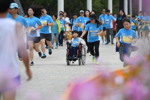 휠체어를 타고 마라톤에 참가한 어린이의 모습.  박윤슬 기자 seul@seoul.co.kr