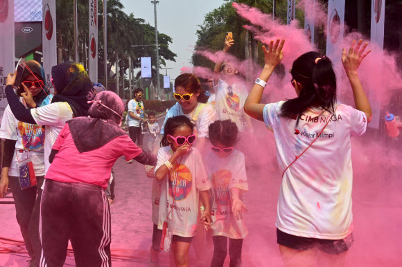 사람들이 13일(현지시간) 인도네시아 자카르타에서 열린 ‘5km 컬러 런(a five-kilometre Colour Run)’에 참가해 즐거운 시간을 보내고 있다. 수천 명이 달리기에 참여해 건강한 생활방식을 고취하는 데 집중했다. AFP 연합뉴스