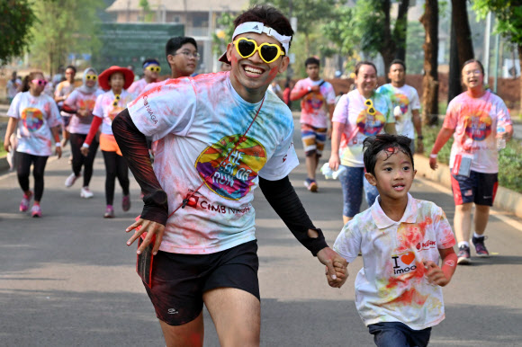 사람들이 13일(현지시간) 인도네시아 자카르타에서 열린 ‘5km 컬러 런(a five-kilometre Colour Run)’에 참가해 즐거운 시간을 보내고 있다. 수천 명이 달리기에 참여해 건강한 생활방식을 고취하는 데 집중했다. AFP 연합뉴스