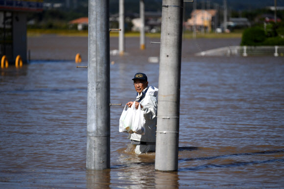 식료품 들고 침수지역 지나는 日 봉사자