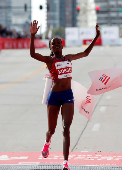 케냐의 여성 마라토너 브리지드 코스게이가 14일(한국시간) 미국 시카고마라톤을 2시간14분4초의 세계신기록으로 완주한 뒤 결승선을 통과하고 있다. 시카고 로이터 연합뉴스