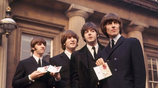 비틀스 멤버들이 1965년 대영제국 훈장을 받은 뒤 버킹엄궁 입구에서 자랑스럽게 들어 보이고 있다. PA 미디어 자료사진  