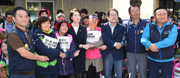 학교 비정규직 노동자들과 교육 당국이 임금 교섭에 합의를 이룬 15일 유은혜 사회부총리 겸 교육부 장관과 조희연 서울시 교육감이 서울 청와대 앞에서 농성중인 조합원들과 김명환 민주노총 위원장을 만나 손을 맞잡고 있다. 2019.10.15. 오장환 기자 5zzang@seoul.co.kr
