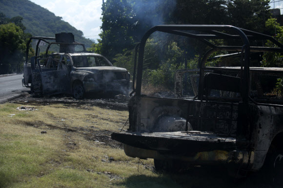 마약 카르텔의 보복 공격으로 불탄 경찰 수송 차량
