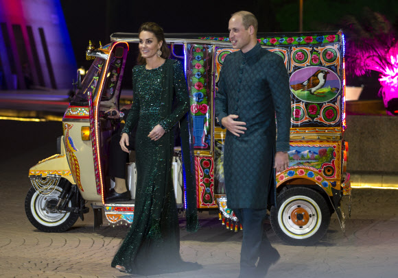 윌리엄 영국 왕자와 케이트 미들턴 왕자비 부부가 15일(현지시간) 파키스탄 이슬라마바드의 한 유적지 앞에 릭쇼를 타고 와 내린 뒤 사진기자들을 포즈를 취하고 있다.  이슬라마바드 AP 연합뉴스