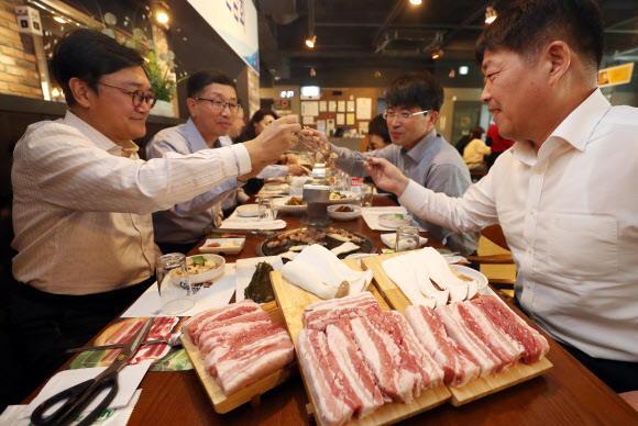 지난 15일 대구시 서구 대구경북양돈조합 직영음식점에서 열린 돼지고기 소비촉진 행사에서 참석자들이 국내산 삼겹살을 시식하고 있다.  대구 연합뉴스