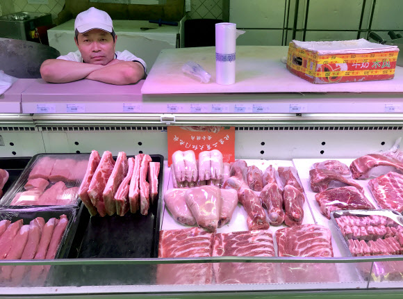 중국 베이징의 한 슈퍼마켓에서 돼지고기 판매업자가 안타까운 표정으로 손님을 기다리고 있다. 서울신문 DB
