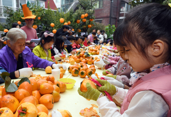 24일 서울 광진구 구립수호천사어린이집에서 열린 ‘3대가 나누는 핑크 바이러스 곶감 사랑 행사’에서 어르신들과 어린이들이 곶감을 만들고 있다. 2019. 10. 24. 박윤슬 기자 seul@seoul.co.kr