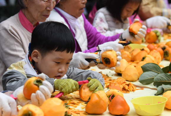 24일 서울 광진구 구립수호천사어린이집에서 열린 ‘3대가 나누는 핑크 바이러스 곶감 사랑 행사’에서 어르신들과 어린이들이 곶감을 만들고 있다. 2019. 10. 24. 박윤슬 기자 seul@seoul.co.kr