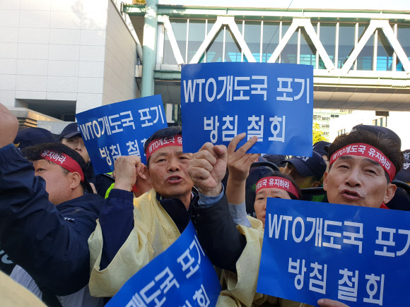 25일 외교부 정문 앞에서 농민단체 회원들이 WTO 개도국 포기 방침 철회를 요구하며 구호를 외치고 있다. 연합뉴스
