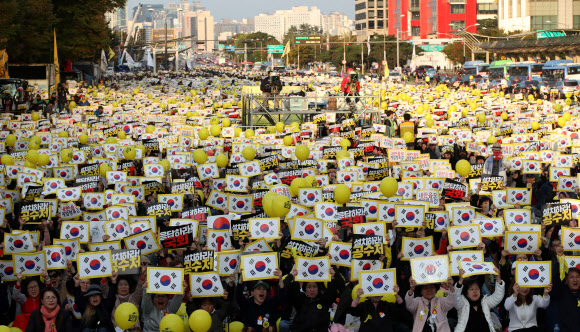 26일 오후 서울 영등포구 여의도공원에서 열린 제11차 사법적폐청산을 위한 검찰개혁 촛불문화제에서 참석자들이 태극기가 그려진 손피켓을 들고 구호를 외치고 있다. 2019.10.26  연합뉴스