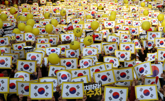 26일 오후 서울 영등포구 여의도공원에서 열린 제11차 사법적폐청산을 위한 검찰개혁 촛불문화제에서 참석자들이 태극기가 그려진 손피켓을 들고 구호를 외치고 있다. 2019.10.26  연합뉴스