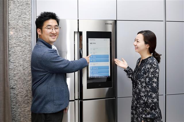 삼성물산 직원들이 입주민의 생활양식에 맞춰 제어되는 ‘래미안 IoT 플랫폼’의 기술이 적용된 주방 가전을 살펴보고 있다. 삼성물산 제공