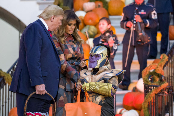 도널드 트럼프(왼쪽) 대통령과 멜라니아 트럼프 영부인이 28일(현지시간) 할로윈을 위해 장식된 백악관의 남쪽 잔디밭에서 할로윈 행사 중에 아이들에게 사탕을 나눠주고 있다. AP 연합뉴스