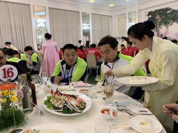 2019년 10월 28일 오후 평양 옥류관에서 2019 아시아 유소년·주니어 역도선수권 대회 고별만찬이 열려 종업원이 음식을 덜어주고 있다. 2019. 10.29. 사진공동취재단