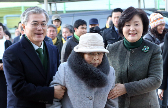 18대 대통령선거가 시작된 19일 민주통합당 문재인 대선 후보와 부인 김정숙 여사가 부산 사상구에서 투표를 마친 뒤 어머니와 함께 영도구 남항동 남중학교에 마련된 투표소를 찾고 있다.    2012.12.19  연합뉴스 자료사진