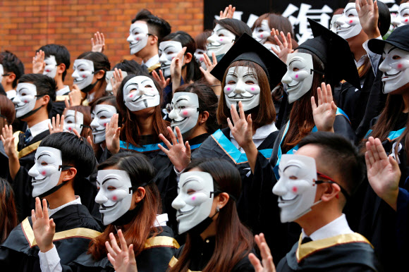 30일 홍콩 이공대 졸업생들이 민주화 시위를 지지하고자 가이 포크스 가면을 쓰고 사진 촬영을 하고 있다.  로이터 연합뉴스