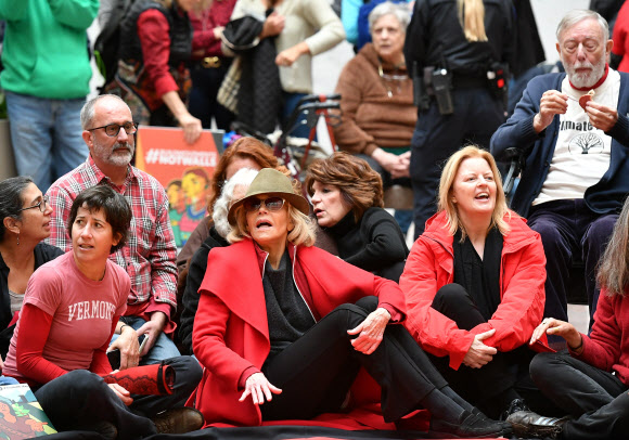 배우이자 활동가인 제인 폰다(가운데)가 1일(현지시간) 미국 워싱턴 DC의 하트 상원 사무소 건물 내부에서 ‘기후 변화 시위’를 하기위해  활동가들과 함께 앉아 있다. AFP 연합뉴스