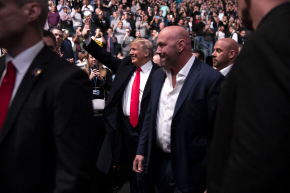 종합격투기(MMA) 팬이자 UFC와 깊은 인연을 갖고 있는 도널드 트럼프 미국 대통령이 데이나 화이트 UFC 대표의 안내로 2일(현지시간) UFC 244가 열린 뉴욕 매디슨 스퀘어가든에 도착해 관객들에게 손을 들어 인사하고 있다. 뉴욕 AP 연합뉴스 