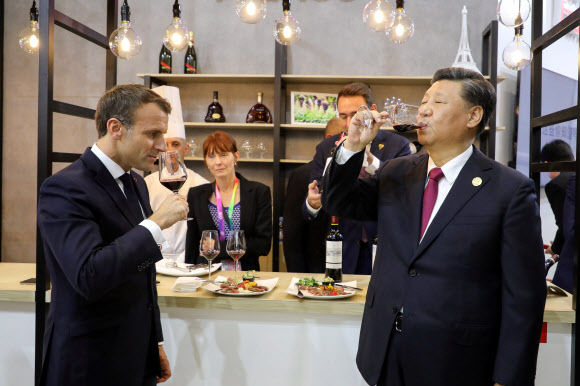 시진핑(오른쪽) 중국 국가주석과 에마뉘엘 마크롱(왼쪽) 프랑스 대통령이 5일(현지시간) 중국 상하이에서 개최된 ‘국제수입박람회’의 프랑스 전시관을 찾아 프랑스 음식과 와인을 맛보았고 사진은 와인을 시음하고 있다. AFP 연합뉴스
