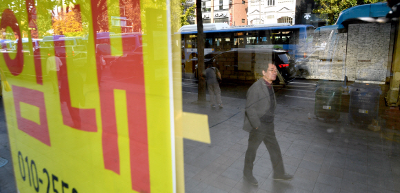 5일 종로의 한 거리에 임대 플래카드를 내건 공실건물 유리창으로 지나는 시민들의 모습이 비치고 있다. 2019.11.5 박지환기자 popocar@seoul.co.kr