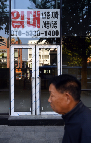 5일 종로의 한 거리에 임대 플래카드를 내건 공실건물앞을 시민들이 지나고 있다. 2019.11.5 박지환기자 popocar@seoul.co.kr