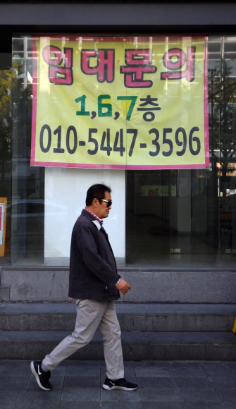 5일 종로의 한 거리에 임대 플래카드를 내건 공실건물앞을 시민들이 지나고 있다. 2019.11.5 박지환기자 popocar@seoul.co.kr