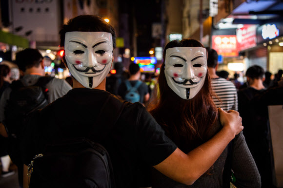 홍콩의 반정부 시위대가 5일(현지시간) 영화 ‘브이 포 벤데타’에 등장해 저항의 상징이 된 ‘가이 포크스’ 가면을 쓴 채 거리를 행진하고 있다.  AFP 연합뉴스