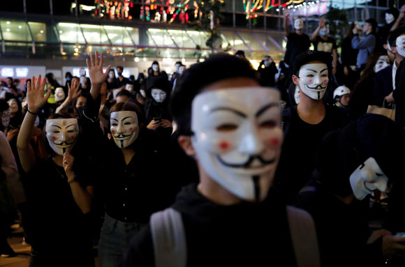 홍콩의 반정부 시위대가 5일(현지시간) 영화 ‘브이 포 벤데타’에 등장해 저항의 상징이 된 ‘가이 포크스’ 가면을 쓴 채 거리를 행진하고 있다.  로이터 연합뉴스
