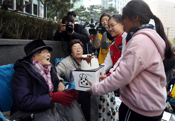 6일 서울 종로구 중학동 옛 일본대사관 앞에서 열린 ‘일본군 성노예제 문제 해결을 위한 제1412차 정기 수요시위’에서 생일을 맞은 이옥선 할머니(왼쪽)가 생일 케이크를 받고 있다. 왼쪽 두번째는 이용수 할머니. 2019.11.6  연합뉴스
