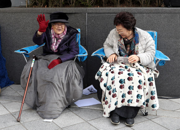 6일 서울 종로구 중학동 옛 일본대사관 앞에서 열린 ‘일본군 성노예제 문제 해결을 위한 제1412차 정기 수요시위’에서 생일을 맞은 이옥선 할머니(왼쪽)가 손을 들어 인사하고 있다. 오른쪽은 이용수 할머니. 2019.11.6  연합뉴스